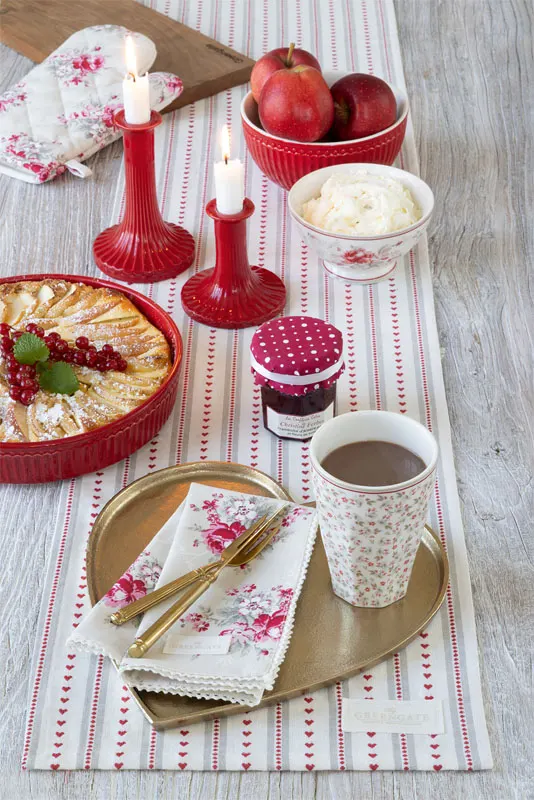 Dukat julbord med rosenmönstrad löpare, röda ljusstakar och äppelpaj